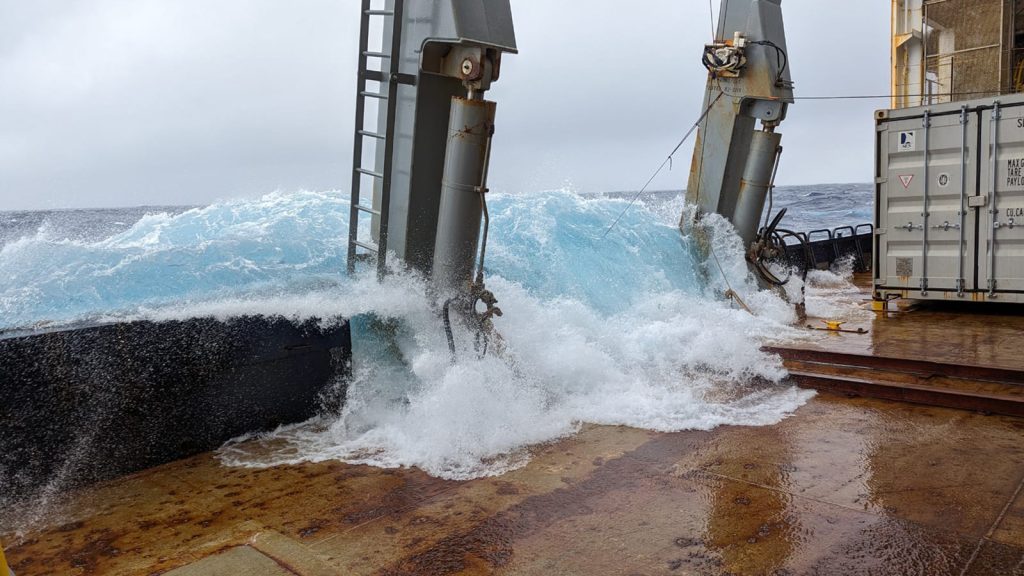 A wave crashes over the side and onto the deck of the R/V Marcus Langseth.